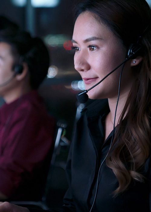 Young Thai Asian customer services care operators working night shift in call center for helping assistance client in workplace at night time